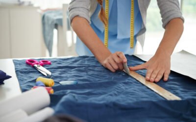 Hands of tailor drawing on fabric before sewing