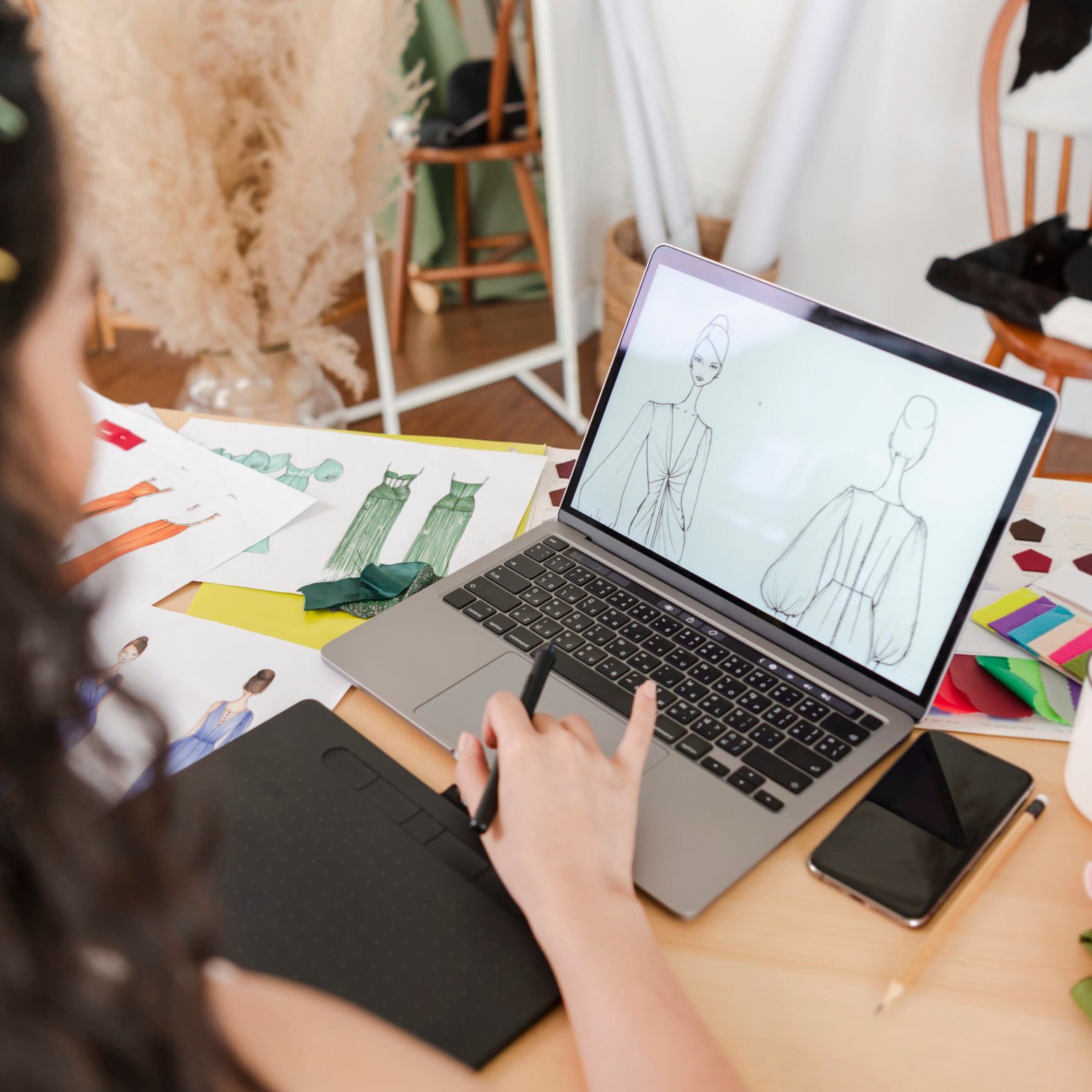 Beautiful asian Fashion designer drawing sketches for new collection on computer laptop. Designer creative workshop studio.